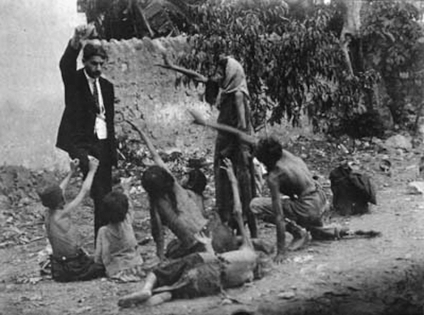 14 - Turkish official teasing starved Armenian children by showing bread during the Armenian Genocide 1915